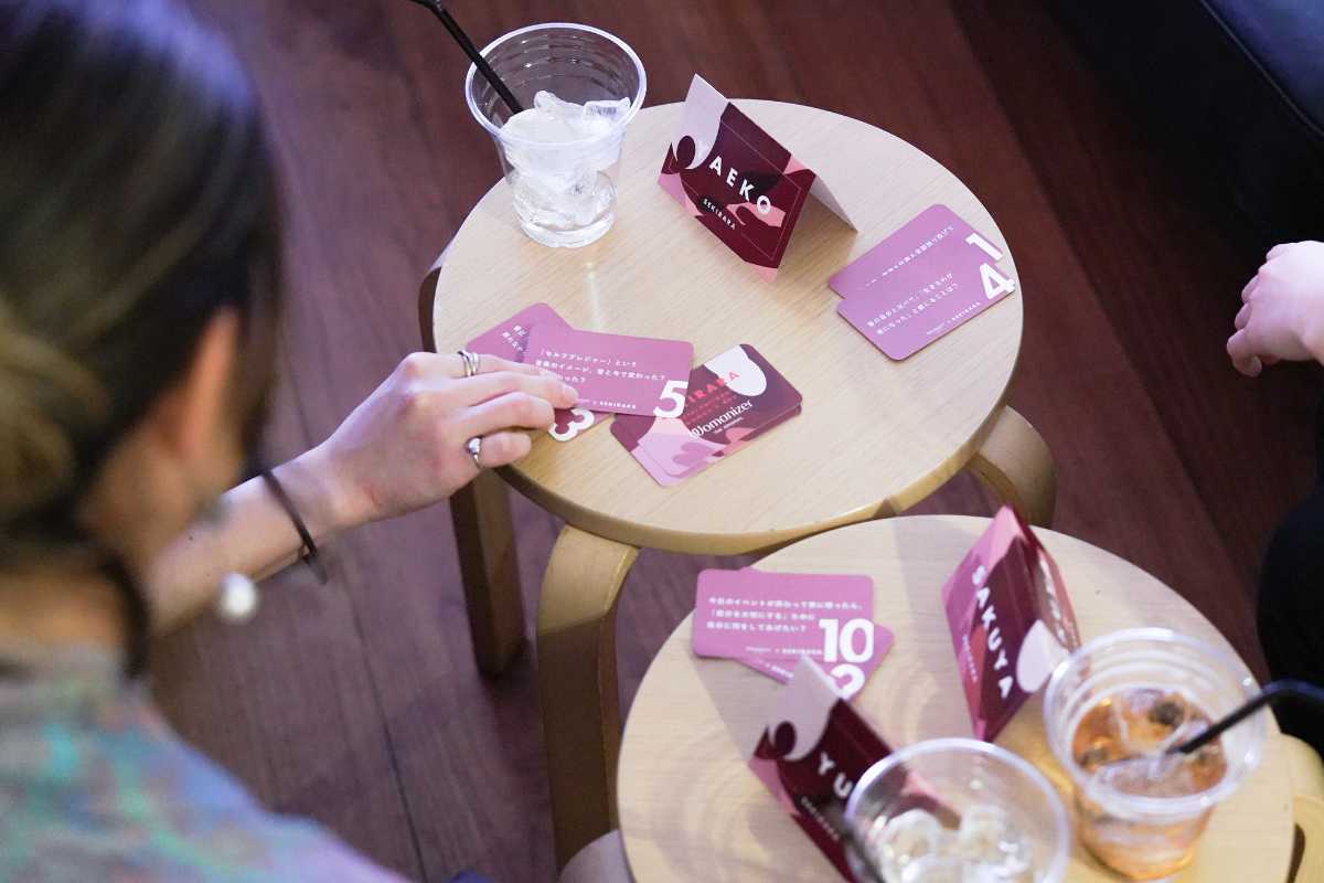 参加者がテーブルを囲んでカードを手にしている様子